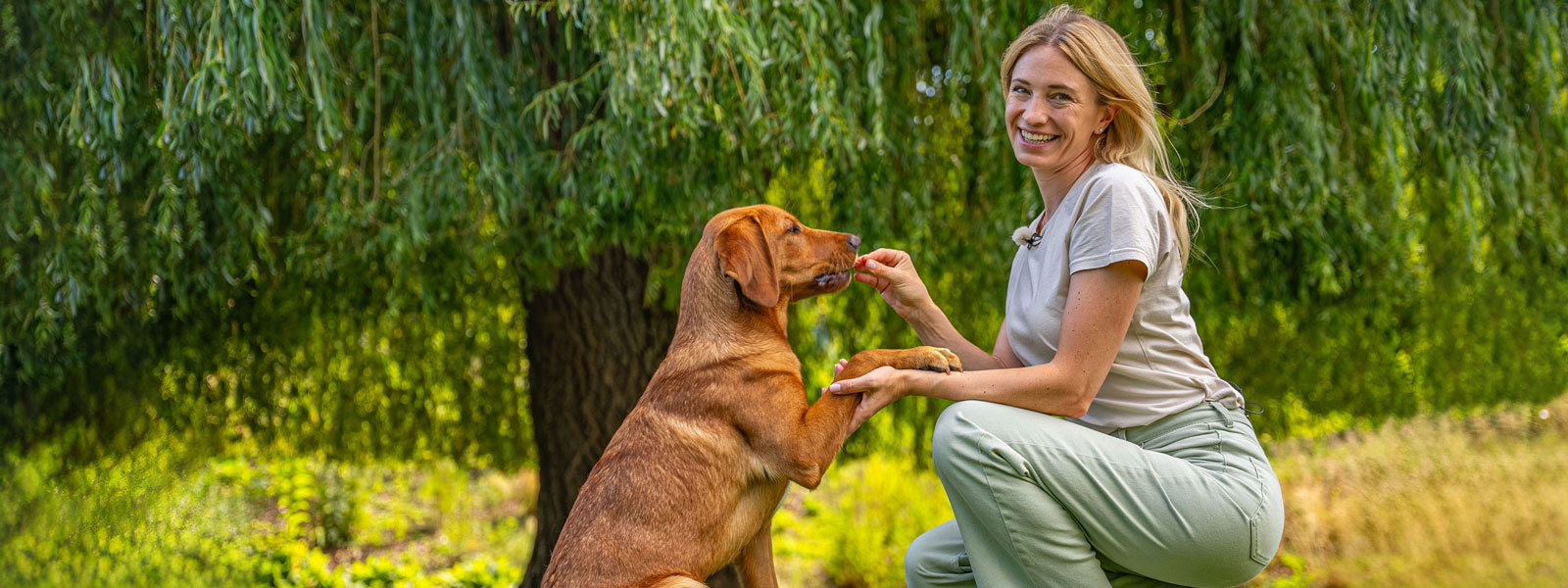 Katharina Miklauz mit ihren Hunden Fynn, wie sie ihm einen Snack gibt