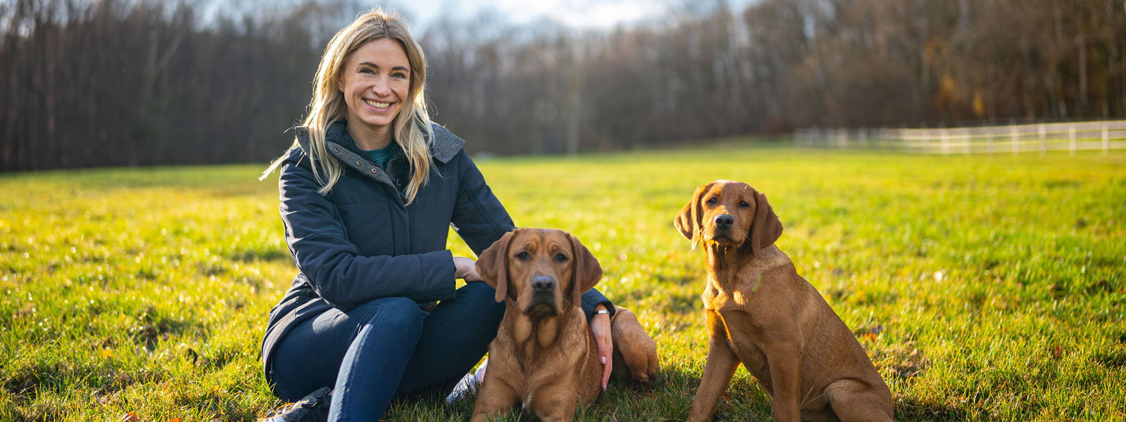 Katharina Miklauz mit ihren Hunden Fynn und Daisy auf einer Wiese
