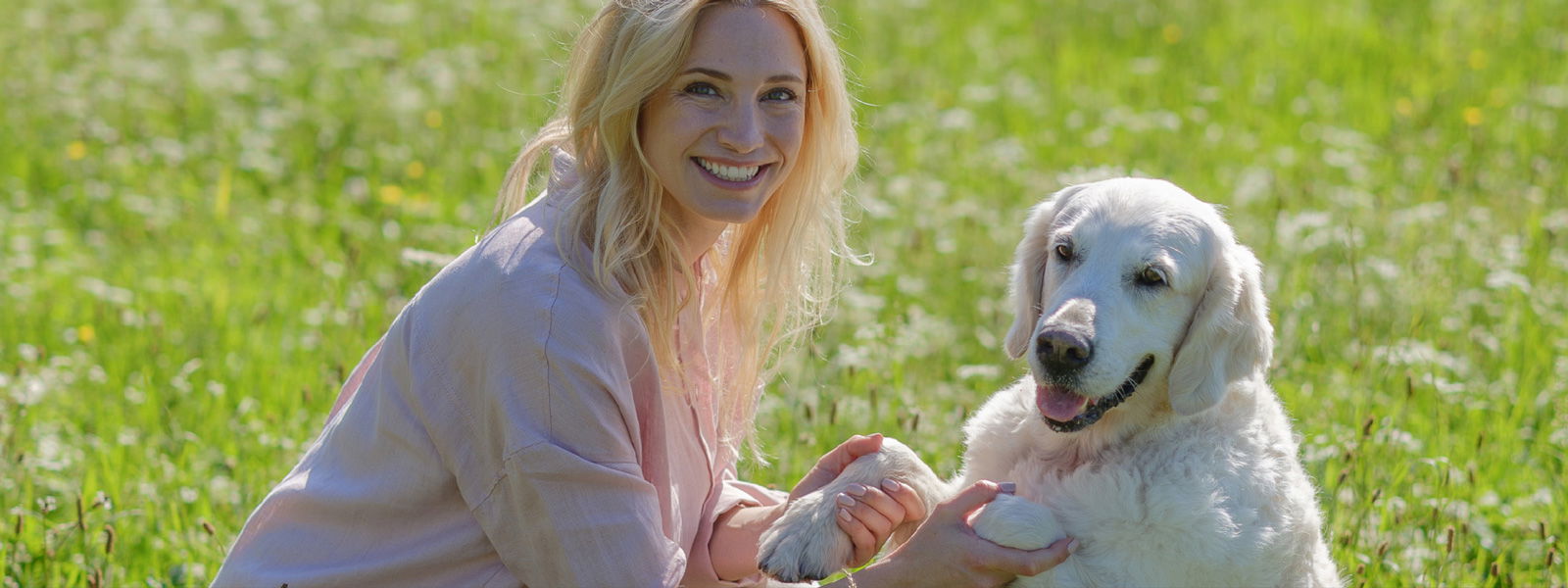 Katharina Miklauz sitzt mit ihrer Hündin Nala auf der Wiese